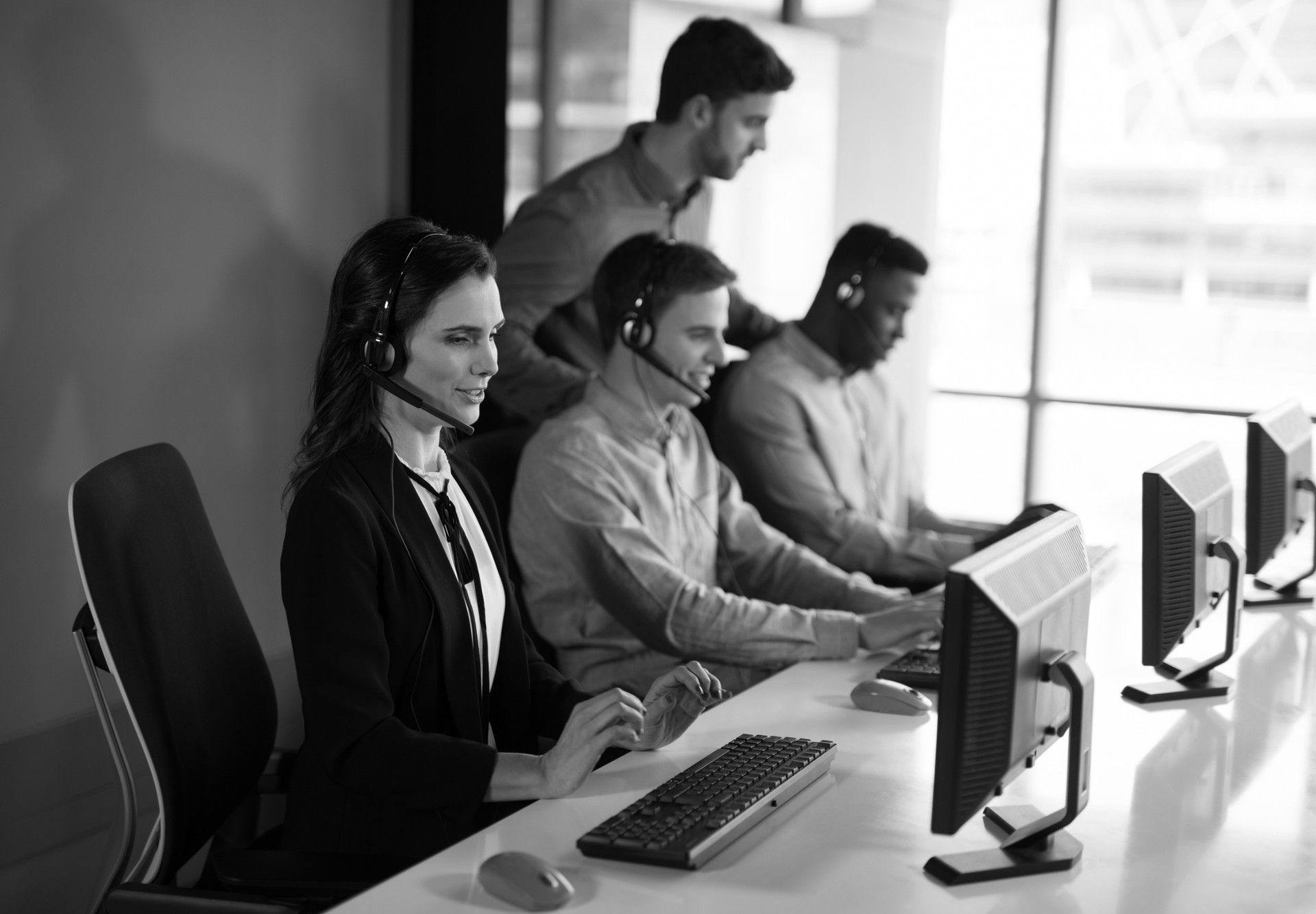 Customer support team assisting clients at computers